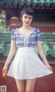 A woman in a white dress holding an orange.