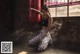 A woman sitting on the ground next to a punching bag.