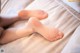 A close up of a person's bare feet on a bed.