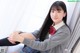 A young woman sitting on a window sill with her legs crossed.