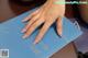 A woman's hand on top of a blue book.