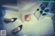 A woman standing on a tiled floor next to a pair of black shoes.