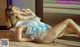 A woman in a blue and white lingerie laying on the floor.