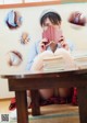 A woman sitting at a table reading a book.