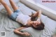 A woman laying on top of a bed next to a window.