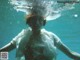 A woman in a white shirt is underwater in the water.